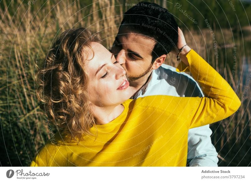 Glückliches Paar umarmt sanft in der Natur Umarmung Liebe Angebot Umarmen Feld sonnig Sommer Partnerschaft Augen geschlossen Freundin Windstille Zusammensein