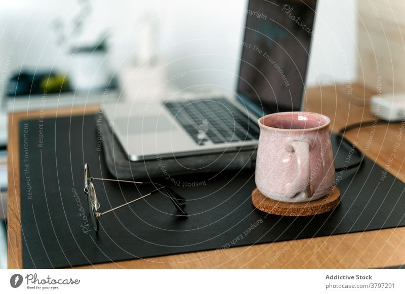 Arbeitsplatz mit modernem Laptop und Brille Apparatur Büro Zeitgenosse Netbook Gerät Schreibtisch Arbeitsbereich schwarzer Bildschirm Browsen Appartement