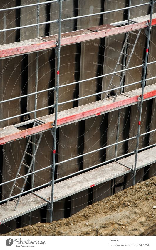 Beim Leiterspiel auf der Baustelle, schafft man mit viel Glück den Aufstieg aus der Baugrube. Über das Gerüst auf die nächste Ebene. Baugerüst Ebenen