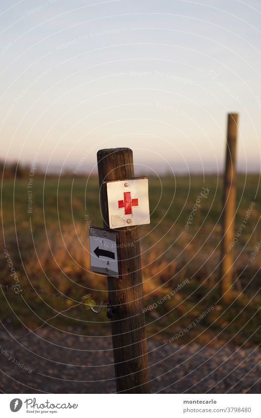 Hinweis auf erste Hilfe beim Wandern Außenaufnahme Farbfoto Detailaufnahme Pfeil Hinweisschild hinweis Erste Hilfe hilfe rot rotkreuz metall tageslicht alt