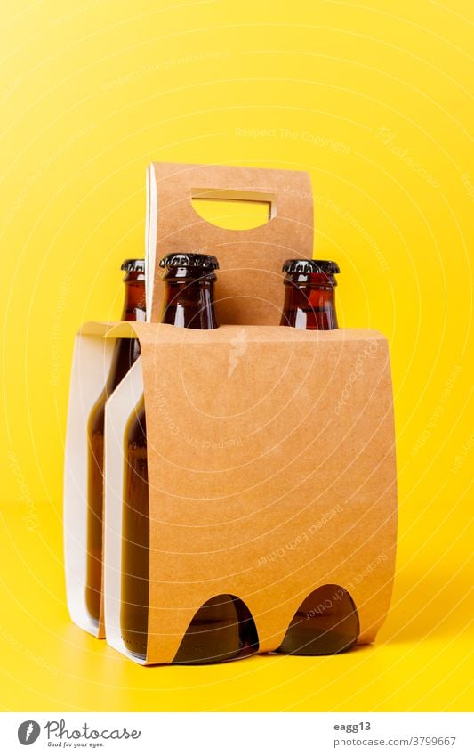 Präsentation einer Packung von vier Bieren mit gelbem Hintergrund bayerisch Belgier Getränk Schnaps Flasche Flaschen Kasten Marke Markenbildung Brauerei