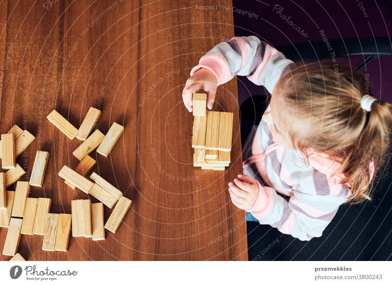 Kleines Mädchen im Vorschulalter spielt mit Holzklötzen Spielzeug, das ein Haus baut Aktivität Klotz Blöcke Baustein bauen Kind Kindheit Konzept Konstruktion