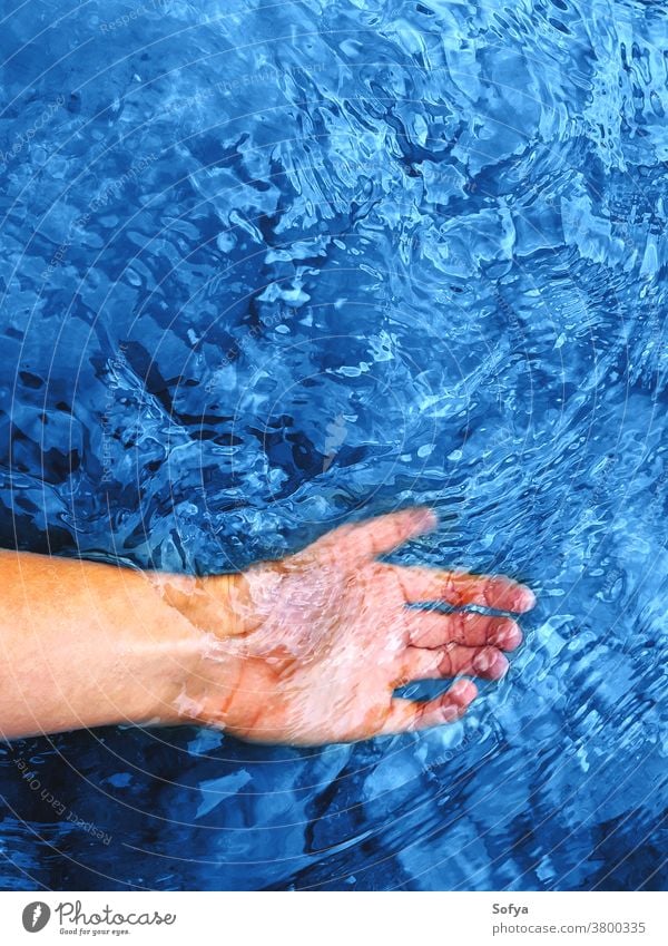 Klassische blaue Farbe des Jahres 2020. Hand im Flusswasser klassisch Frau Harmonie Wasser Urlaub Hintergrund Stilrichtung Klassik Rippeln natürlich trendy Mode