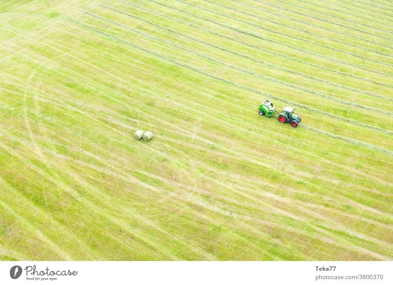 ein Traktor macht Heu von oben Traktor beim Heuen Traktor, der von oben Heu macht Traktor von oben grün gelb rot weiß Bauernhof Landwirtschaft moderner Traktor