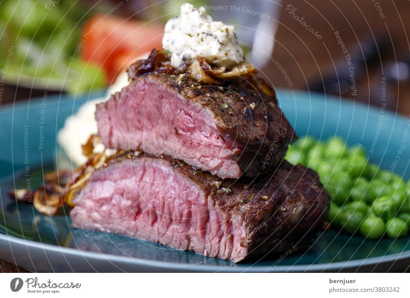 gegrilltes Steak mit gerösteten Zwiebeln Rindfleisch Erbse Butter halbiert Hälfte Kräuterbutter Püree Kartoffelbrei Fleisch Essen Abendessen Braten Sirloin