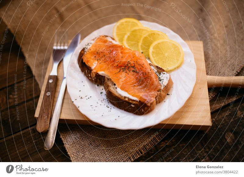 Räucherlachs mit Käse, geröstetem Brot, Zitrone und Joghurt-Dip geräuchert Frischkäse Zuprosten Crostini vorbereitet serviert Scheibe Teller Speise Tisch