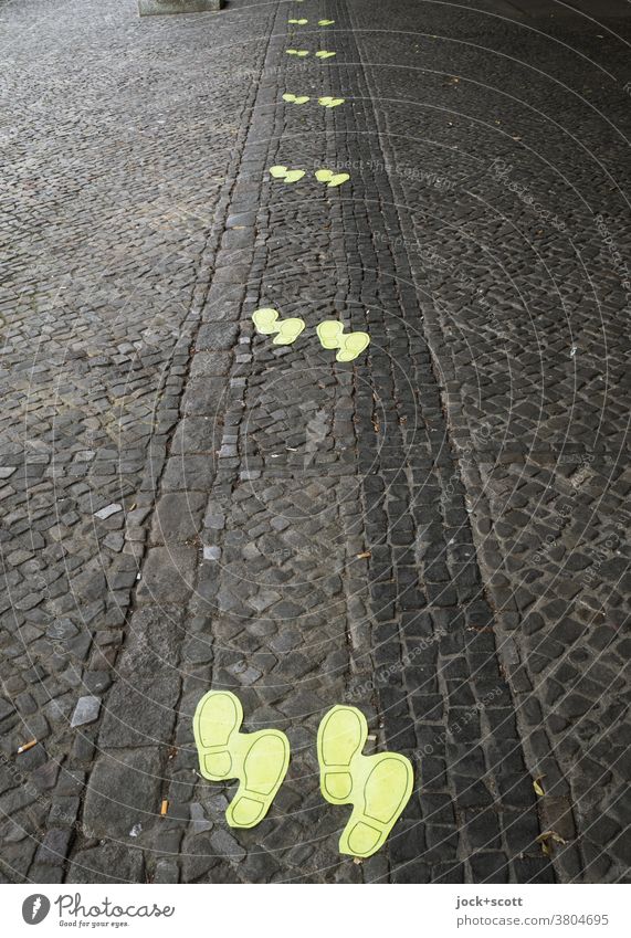 Mindestabstand von 1,5 Meter durch Schuhabdruck Bodenmarkierung mindestens sicherheitsabstand Abstand Kopfsteinpflaster Abstand halten Warteschlange Hinweis