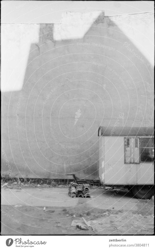 Bauwagen vor leerer Fassade haus fassadem brandmauer bauwagen baustelle trist traurig melancholie ddr ostberlin licht schatten unbelebt