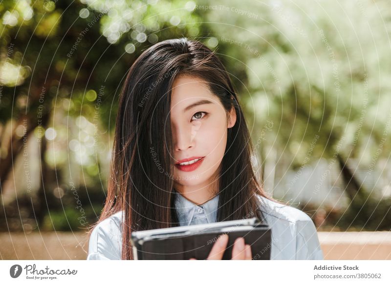 Asiatische Geschäftsfrau mit Tablet im Park Frau Tablette positiv Lächeln Unternehmer Arbeit Job Stil selbstbewusst professionell jung ethnisch asiatisch formal