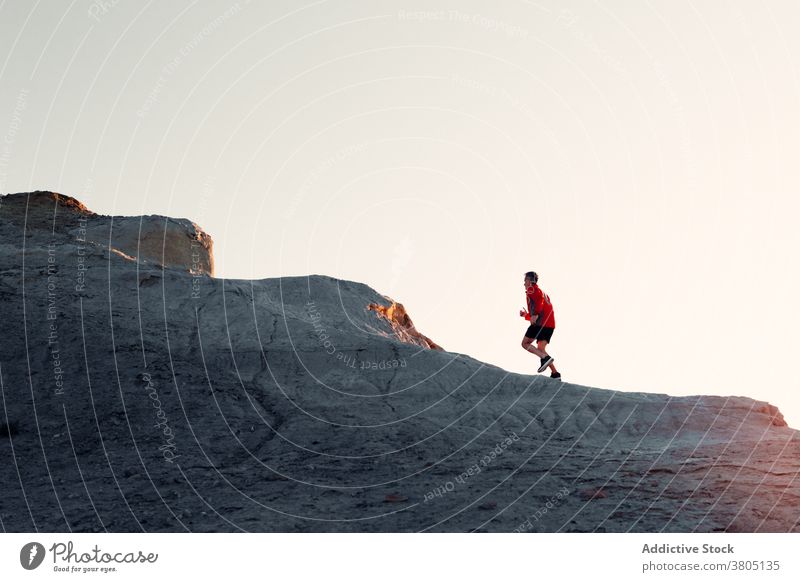 Anonyme Person, die bei Sonnenuntergang auf einem Hügel läuft laufen Berge u. Gebirge Berghang Training Athlet Aufstieg Silhouette Übung Gesundheit Sport