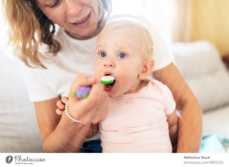 Fröhliche Mutter füttert bezauberndes Baby Frau Säugling Futter essen Kinderbetreuung Bonden Kindheit niedlich Kleinkind Raum Eltern Liebe Zusammensein