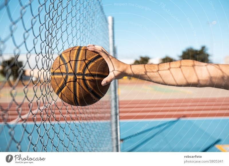 Mann, der auf der Straße auf einem Außenplatz Basketball spielt. Spaß Sport urban Menschen cool Männer Ball Schuss jung Spiel männlich Erwachsener Gericht