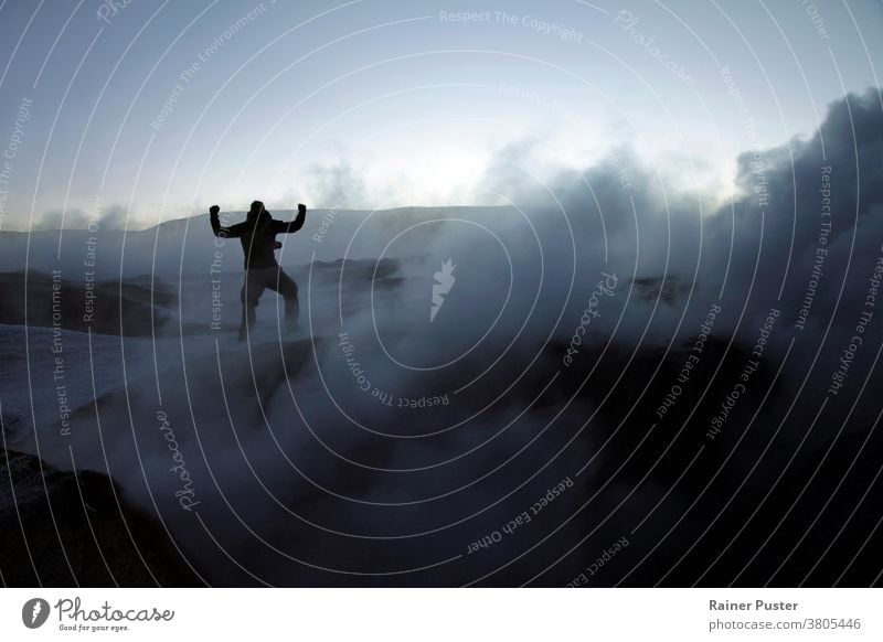 Silhouette eines Mannes inmitten von vulkanischem Rauch auf einem Vulkan in Salar de Uyuni, Bolivien, während des Sonnenaufgangs Errungenschaft Ziele erreichen