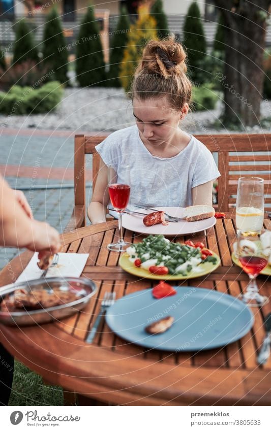 Familie isst während des Sommerpicknicks im Freien in einem Hausgarten zu Abend heimwärts Festessen habend Picknick Lebensmittel Mann Zusammensein Frau Kind