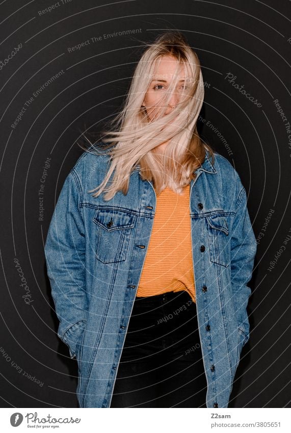 Mode-Portraits einer jungen Frau blond flashlook jeansjacke Paparazzi-Look trashig Modus Pullover Jacke lange haare hübsch Wind wehen Porträt schön Lifestyle