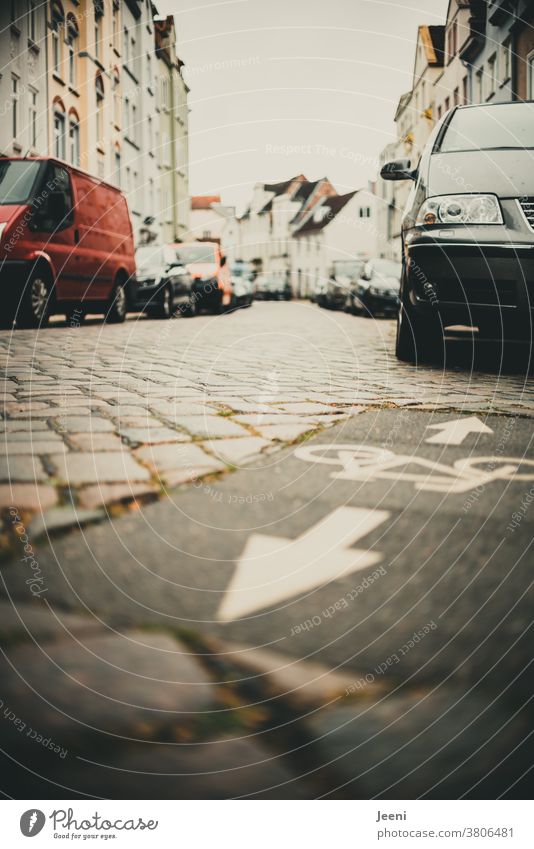 In einer Stadt auf dem Fahrradweg stehen viele Autos und versperren den Fahrradfahrern den Weg versperrt Verkehrswege Autofahrer rücksichtslos eng Straße