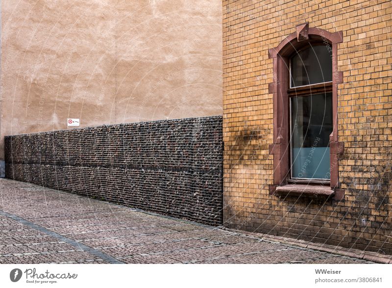 Ton in Ton präsentiert sich die stille kleine Straße Gasse Haus Mauer Zaun Wand Pflaster Fahrbahn Fenster braun gelb Struktur Muster Außenaufnahme Menschenleer