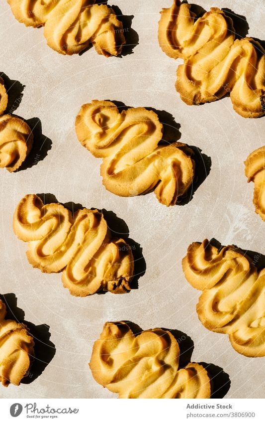 Helle goldene gebackene Kekse mit Ornament auf dem Tisch Biskuit Leckerbissen Gebäck lecker süß kreativ Design Hintergrund dekorativ farbenfroh natürlich