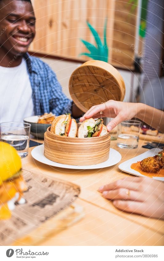 Glückliche verschiedene Freunde beim Abendessen in der Cafeteria sorgenfrei Zahnfarbenes Lächeln Kantine lecker heiter sich[Akk] sammeln hungrig jung