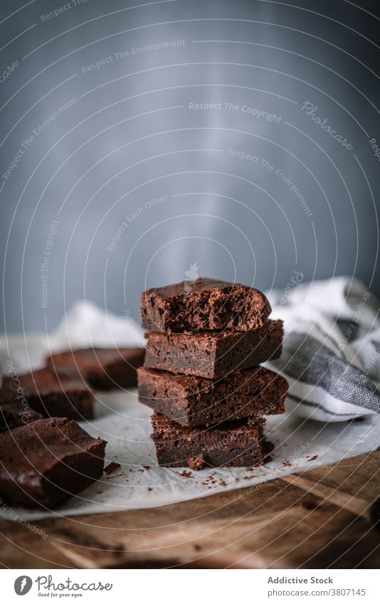 Leckere hausgemachte Brownies auf Pergament in der Küche Spielfigur selbstgemacht Dessert gebacken Leckerbissen süß geschmackvoll Schneidebrett Schokolade Tisch