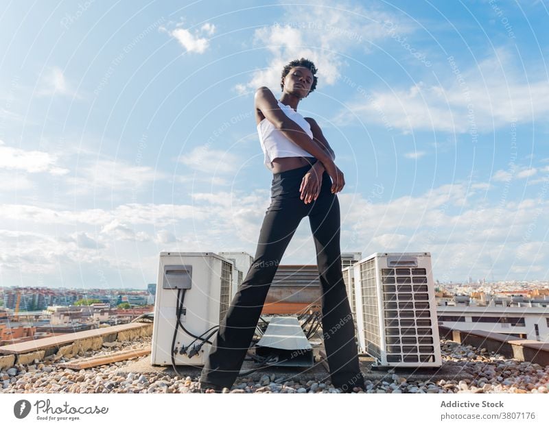 Stilvolle schwarze weibliche Modell stehen anmutig auf dem Dach Frau Dachterrasse Vorschein selbstbewusst Outfit cool Glamour Windstille schlanke positiv