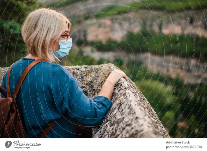 Frau mit Maske beobachtet die Berge von einer alten Burg aus Reisender historisch mittelalterlich Berge u. Gebirge erkunden Felsen Festung Burg oder Schloss