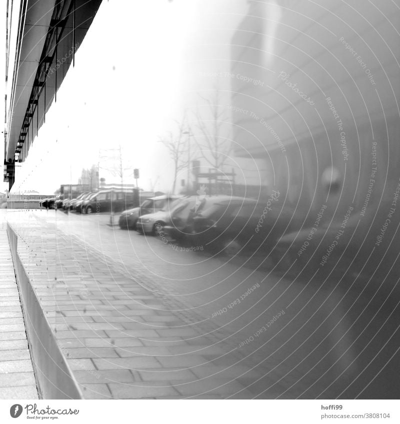 geparkte Autos am Straßenrand, reflektiert von einer Bürofassade Reflektion Reflexion & Spiegelung Reihe Herbst Herbststimmung Nebel herbstnebel Nebelschleier