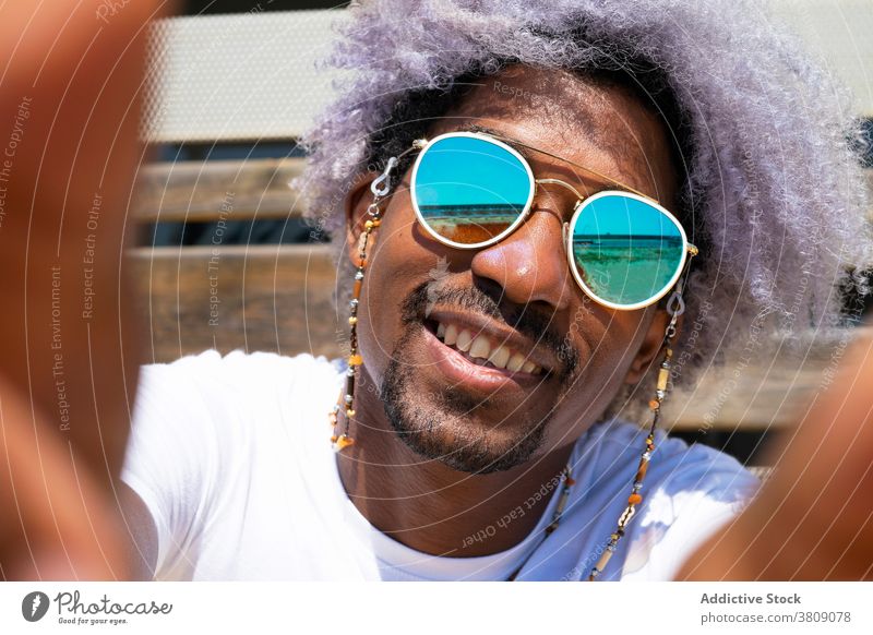 Schwarzer Mann mit Afro-Haar lächelnd und nehmen ein Selfie. Schwarzer Mann einen Selfie nehmend Afrohaar schwarz Lächeln Afrikanisch Amerikaner Afro-Look