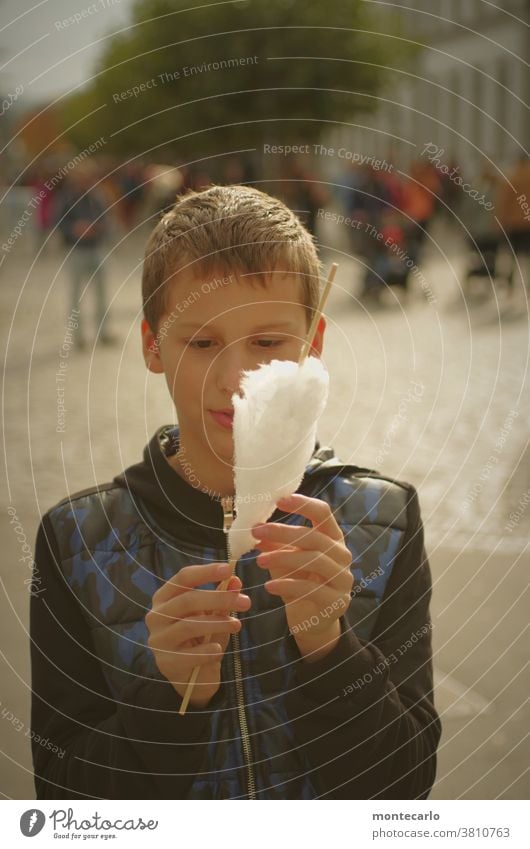 Glücklicher Junge mit Zuckerwatte in der Hand cool Lächeln Vorfreude Stolz Kind Stimmung Porträt Farbfoto Blick 8-13 Jahre Mensch Kindheit Zufriedenheit Neugier