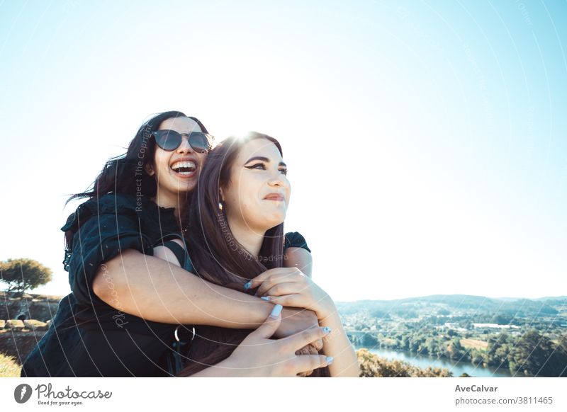 Zwei Frauen, die sich an einem sonnigen Tag amüsieren, während sie lächeln und sich mit Kopierraum umarmen Freundschaft Freude Sonne Fröhlichkeit jung