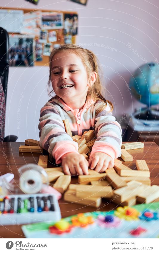 Kleines Mädchen im Vorschulalter spielt mit Holzklötzen Spielzeug, das ein Haus baut Aktivität Klotz Blöcke Baustein bauen Kind Kindheit Konzept Konstruktion