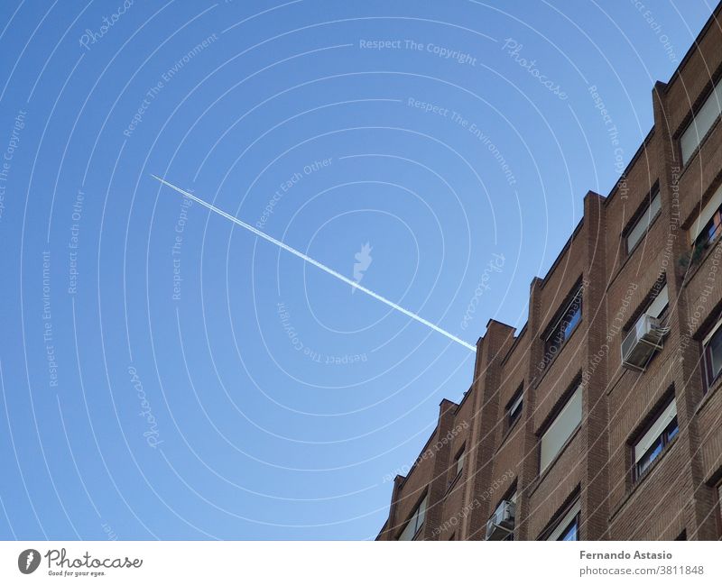 Der weiße Blitz des Flugzeugs, das durch das Gebäude geflogen ist und die Linien zerschnitten hat, in Madrid, Spanien Architektur Himmel Wolkenkratzer Großstadt