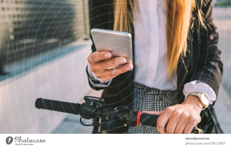 Detail des Mobiles der Geschäftsfrau mit Elektroroller Nahaufnahme Handy Frau Tretroller urban unkenntlich Texten Textnachricht Großstadt Straße Mode Arbeiter