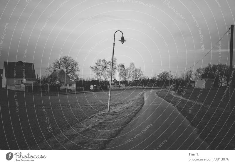 Stille Tage in der Uckermark Dorf s/w b/w Schwarzweißfoto ruhig b&w Einsamkeit Architektur Laterne Straße dunkel Winter Herbst Abenddämmerung Ort Brandenburg