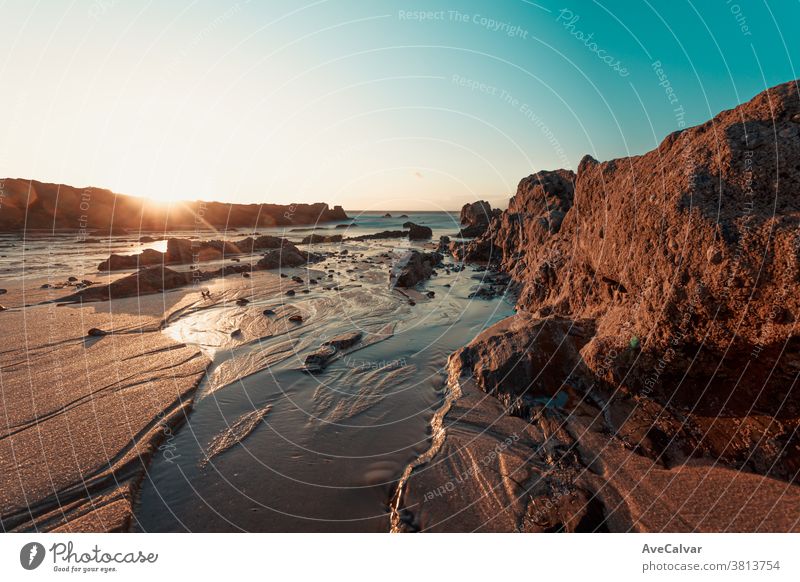 Farbenprächtiger Sonnenuntergang am Strand über den mit Muscheln gefüllten Felsen Szene Küstenlinie niemand Stein Meereslandschaft panoramisch Natur im Freien