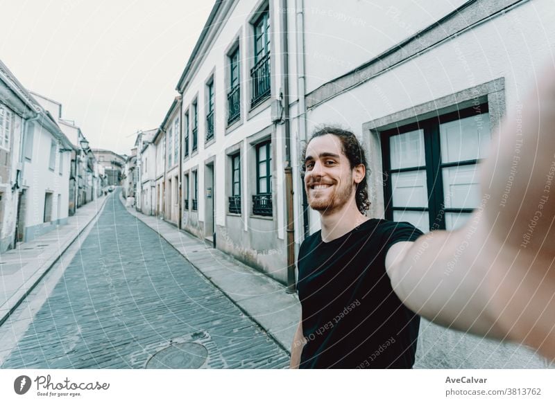 Junger Mann mit Brille bei einem Selbstmord auf einer alten spanischen Straße Foto Urlauber modern bärtig Porträt heiter Glück Hafengebiet Rucksack Selfie