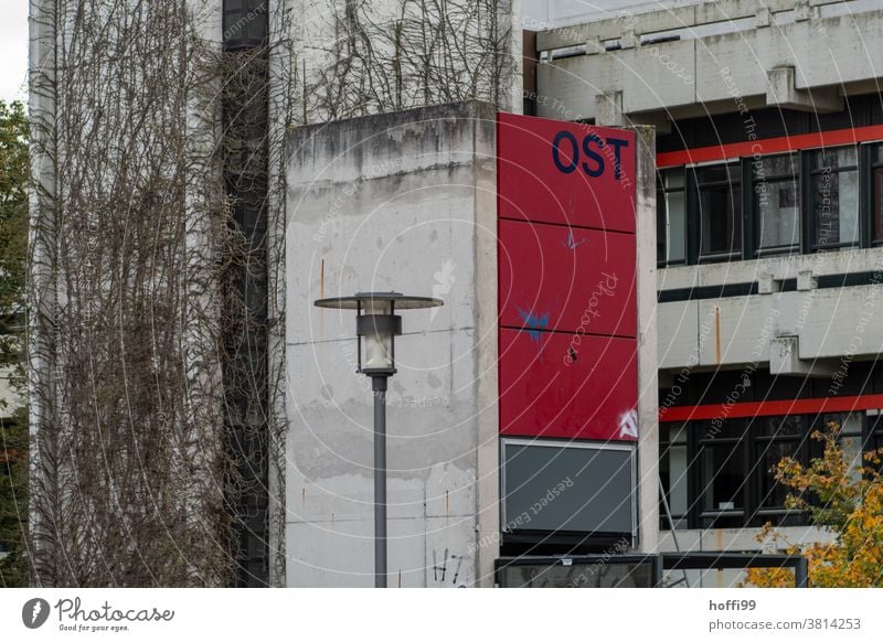 düstere Einsicht in den Zentralbereich einer Beton Konstruktion mit  Ost Turm und Strassenlaterne Betonwand rot Betonklotz ranken Sichtbeton Architektur