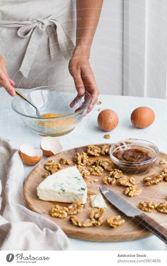 Crop Frau Kochen Blue Käsekuchen in der Küche Pause Ei blau Dessert vorbereiten Hausfrau Bestandteil Walnussholz Glas Schalen & Schüsseln Lebensmittel