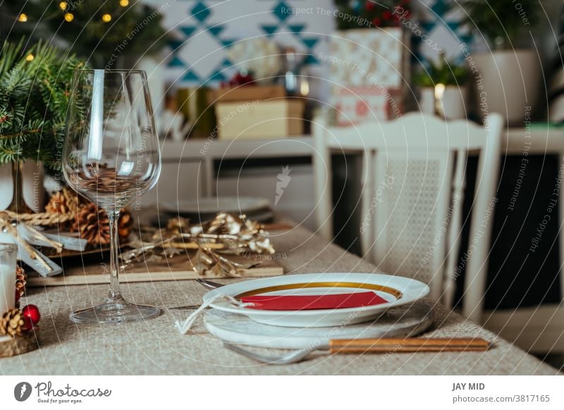 Gemütliche weihnachtliche Tischdekoration, mit Kiefernzweigen rustikale Tischdecke im Wohnzimmer des Hauses. Europäischer Stil mit Weihnachtsbeleuchtung.