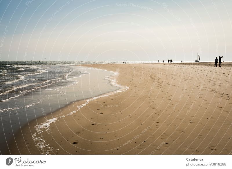 Spaziergänger am  Strand Sand Sandstrand Urlaub Personen Horizont Himmel Nordsee Wellen Brandung Küste Meer Segelyacht schönes Wetter Fußabdrücke spazieren Blau