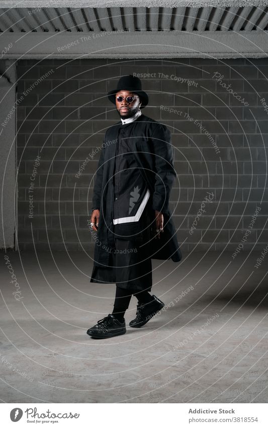 Schwarzer Mann in stilvollem Outfit in der Garage Stil schwarz brutal selbstbewusst Rapper rund Sonnenbrille männlich ethnisch Afroamerikaner unterirdisch Farbe