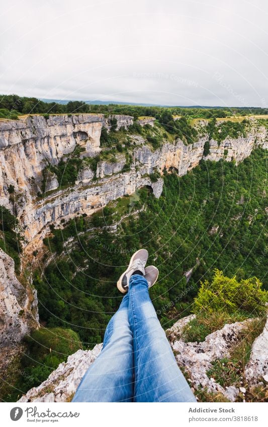 Crop Tourist kontemplieren Berge mit grünen Bäumen Reisender bewundern Berge u. Gebirge Baum Natur Hochland Himmel wolkig vegetieren Beine gekreuzt Atmosphäre