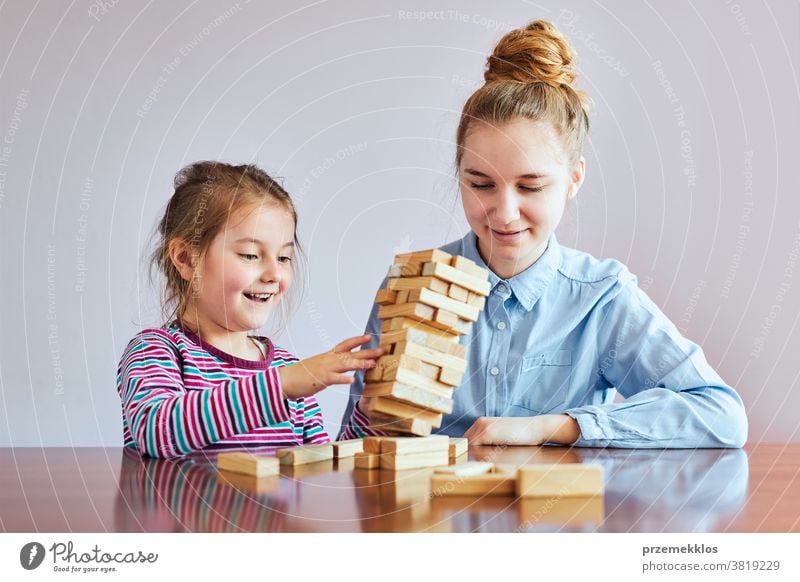 Kleines Mädchen im Vorschulalter und ihre ältere Schwester spielen zusammen mit Holzklötzen Spielzeug Aktivität Klotz Blöcke Baustein bauen Kind Kindheit