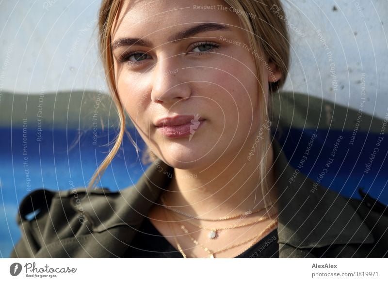 Blondes Mädchen sitzt an einer Wand mit Graffiti Landschaft Strand intensiv jugendlich freundlich Natur weiblich einzigartig außergewöhnlich natürliches Licht