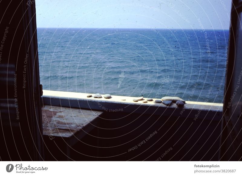 Meer Sehnsucht Blick auf das Meer Balkonbrüstung Steine Kieselsteine retro altehrwürdig Meerblick Wasser Urlaub sehnsucht Fensteraussicht Erholung Sommer Sonne