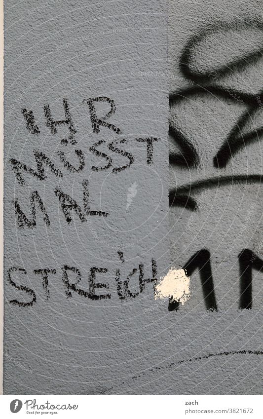 Auf einen Streich Zeichen Wand Fassade Graffiti Mauer Gebäude Street Art Ruine grau streichen Renovieren Maler Buchstaben Botschaft malern Ironie