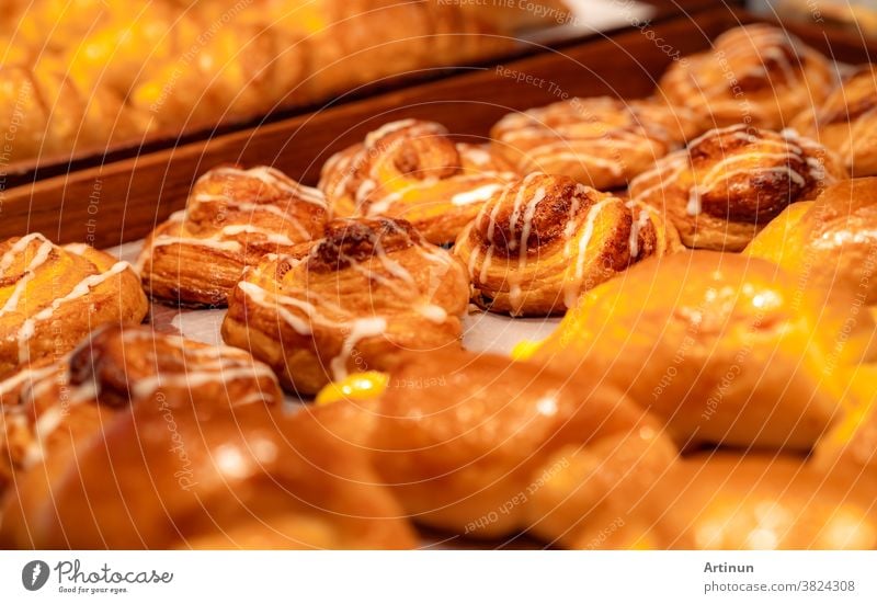 Bäckerei in braunem Holztablett in einer Bäckerei. Frisch gebackenes Gebäck. Auslage für süßes Brot auf der Theke. Kohlenhydrathaltiges Essen. Snack zum Frühstück oder Mittagessen. Bäckerei-Einzelhandelsgeschäft. Hausgemachte Bäckerei.