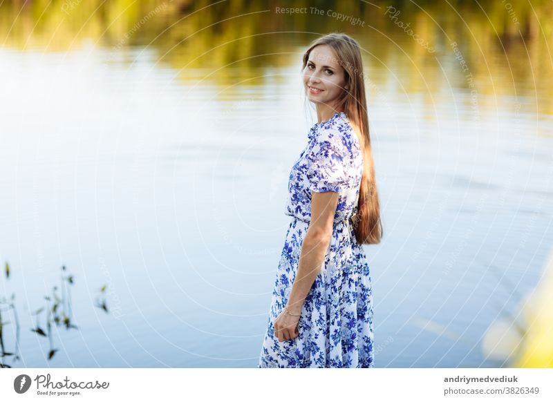 Schönes Porträt einer jungen Frau im Feld. Attraktives brünettes Mädchen mit langer lockiger Frisur in weißem Kleid träumend. Porträt eines schönen langhaarigen Mädchens