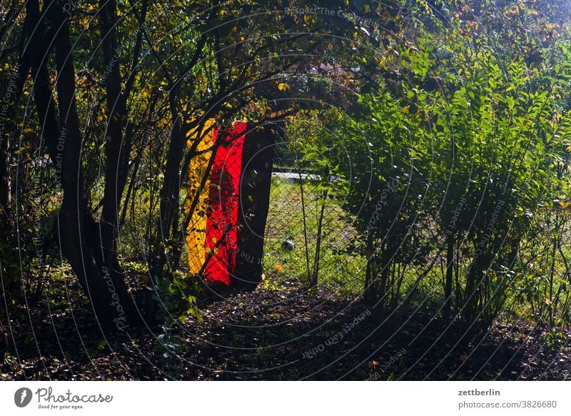 Deutschlandfahne in der Kleingartenkolonie deutschland deutschlandfahne gartenzaun grundstück herbst nationalismus patriotismus kleingarten kleingartenkolonie