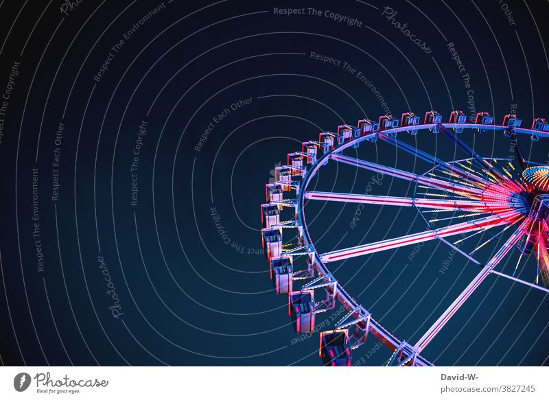 ein leuchtenes Riesenrad am späten Abend ragt in den Himmel empor bunt Kirmes Jahrmarkt freizeit vergnügen Nacht hoch Spaß Aufregung